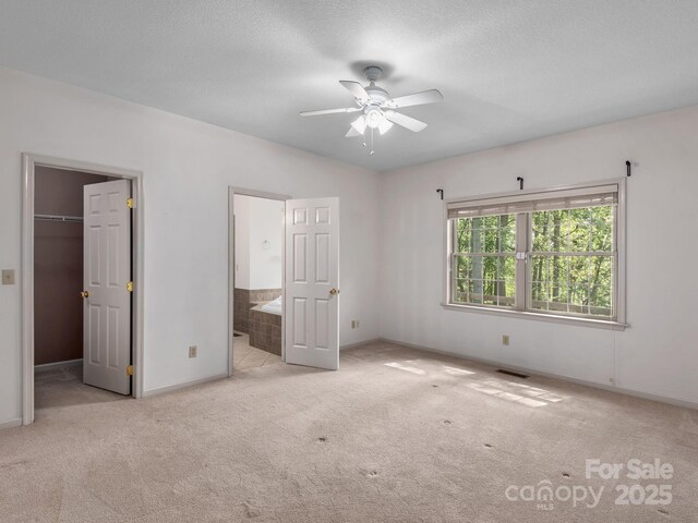 unfurnished bedroom featuring carpet floors, baseboards, and a spacious closet