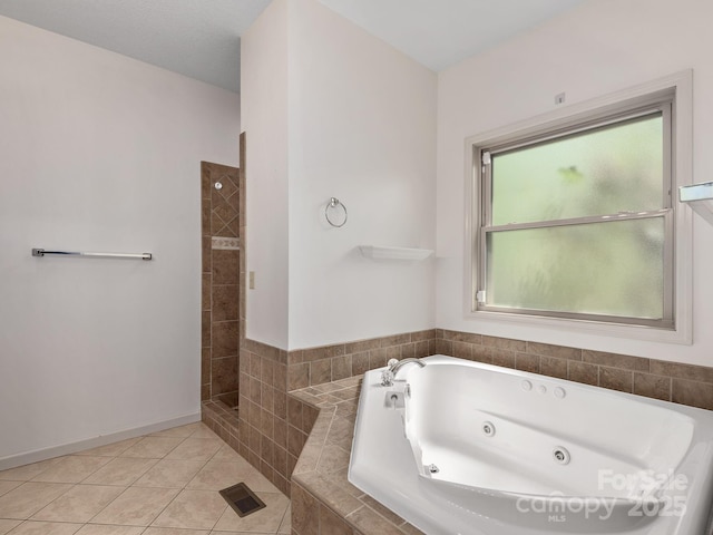 bathroom with tile patterned flooring, a tub with jets, and tiled shower