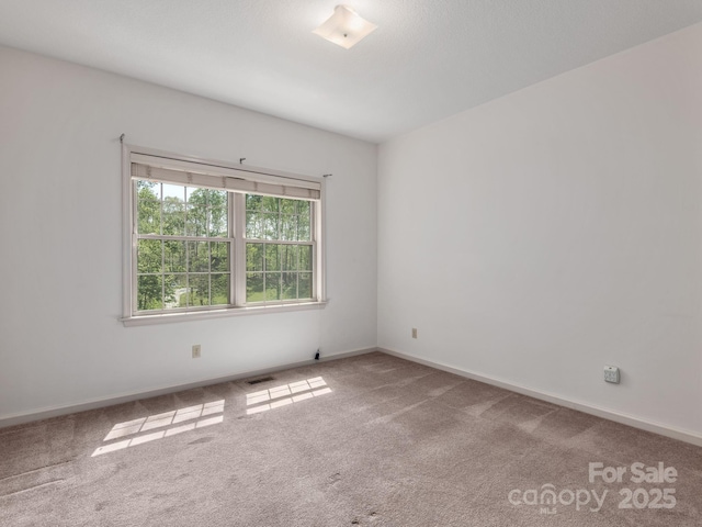 unfurnished room featuring carpet floors, baseboards, and visible vents
