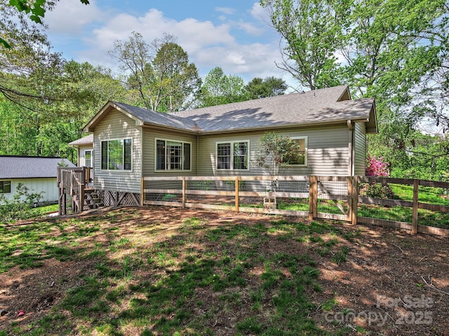 back of property with a gate and fence