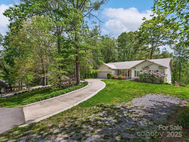 single story home featuring an attached garage, driveway, and a front yard