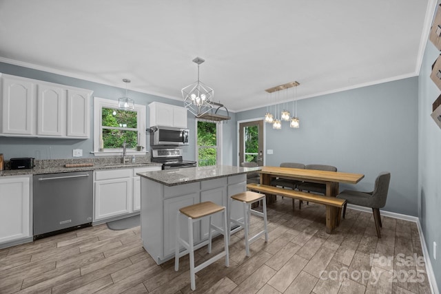 215 Calm Creek Rd, Fletcher, NC 28732 - kitchen featuring stainless steel appliances, a sink, healthy amount of natural light, white cabinetry, and ornamental molding
