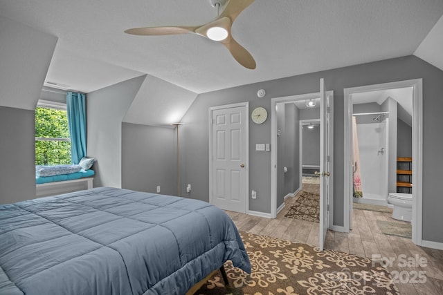 215 Calm Creek Rd, Fletcher, NC 28732 - bedroom featuring vaulted ceiling, light wood-style floors, baseboards, ceiling fan, and a textured ceiling