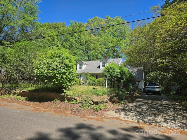 view of side of home featuring driveway and a chimney