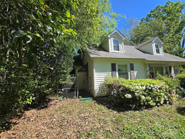 view of front facade featuring fence and a shingled roof