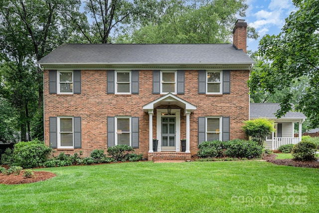 1209 Alfred St, Charlotte, NC 28211 - colonial house featuring a chimney, a front lawn, brick siding, and a shingled roof