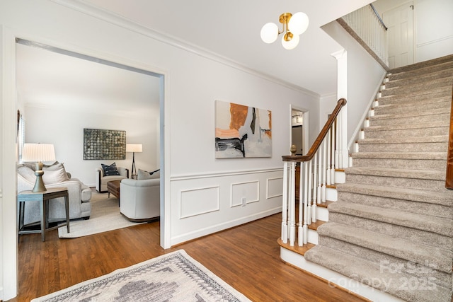 1209 Alfred St, Charlotte, NC 28211 - stairs featuring crown molding, wood finished floors, a chandelier, and a wainscoted wall