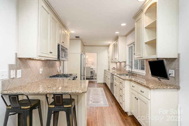 1209 Alfred St, Charlotte, NC 28211 - kitchen with a sink, stainless steel appliances, dark wood-style floors, a kitchen breakfast bar, and tasteful backsplash