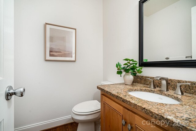 1209 Alfred St, Charlotte, NC 28211 - half bathroom with vanity, toilet, and wood finished floors