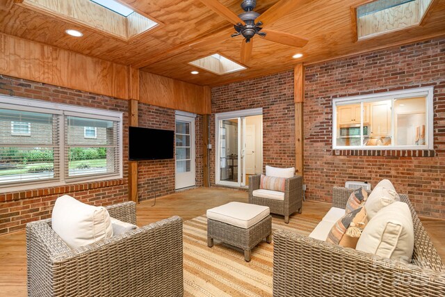 1209 Alfred St, Charlotte, NC 28211 - living area with a skylight, brick wall, wood ceiling, light wood finished floors, and ceiling fan