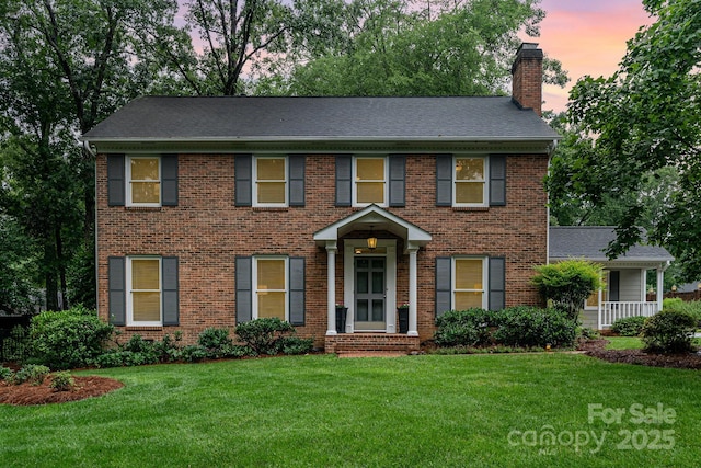 1209 Alfred St, Charlotte, NC 28211 - view of front of house featuring a chimney, a yard, brick siding, and roof with shingles