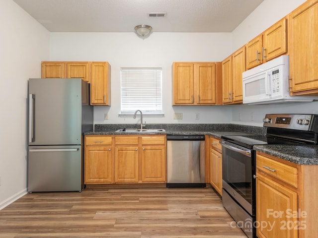 6212 Derryfield Dr, Charlotte, NC 28213 - kitchen featuring stainless steel appliances, light wood finished floors, and dark stone counters
