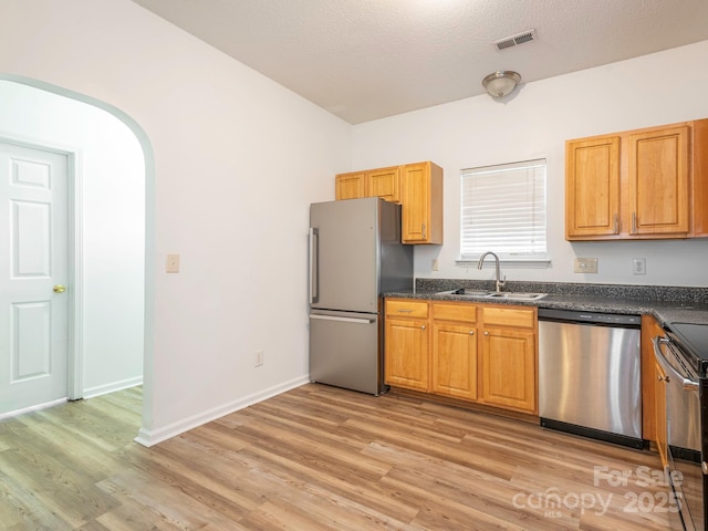 6212 Derryfield Dr, Charlotte, NC 28213 - kitchen with appliances with stainless steel finishes, dark countertops, light wood-style floors, and a textured ceiling