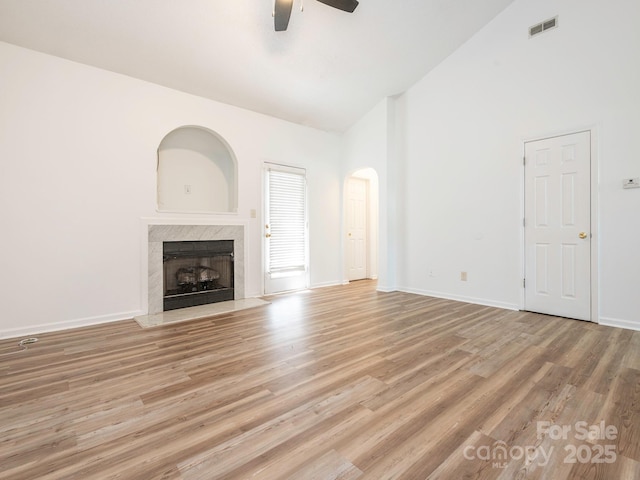 6212 Derryfield Dr, Charlotte, NC 28213 - unfurnished living room featuring high vaulted ceiling, a ceiling fan, a premium fireplace, light wood-style floors, and arched walkways