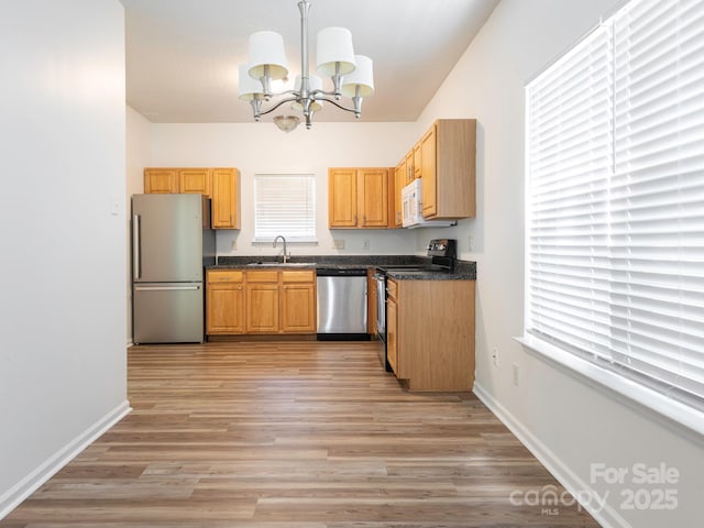 6212 Derryfield Dr, Charlotte, NC 28213 - kitchen with appliances with stainless steel finishes, a chandelier, dark countertops, and light wood finished floors