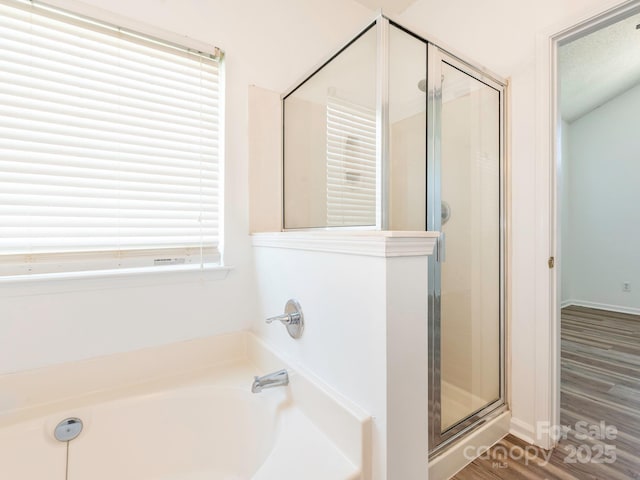 6212 Derryfield Dr, Charlotte, NC 28213 - bathroom with a shower stall, a bath, and wood finished floors