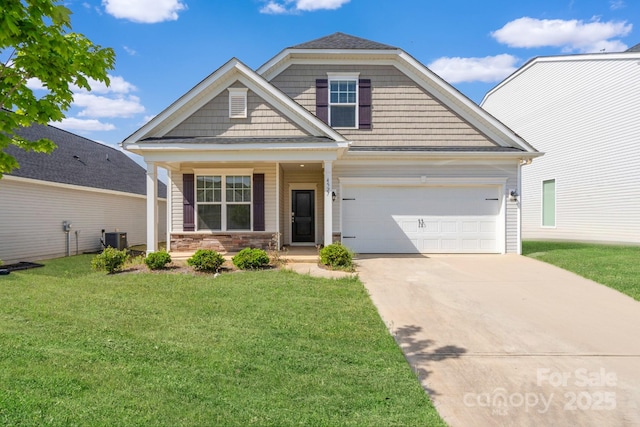 craftsman-style home with a front yard, central AC unit, an attached garage, driveway, and a porch