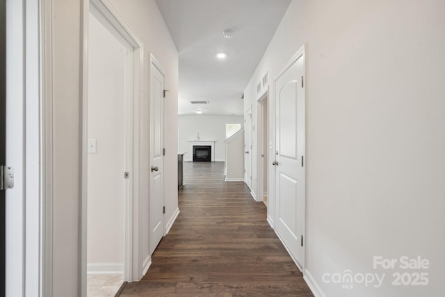 hall featuring recessed lighting, baseboards, visible vents, and dark wood-type flooring