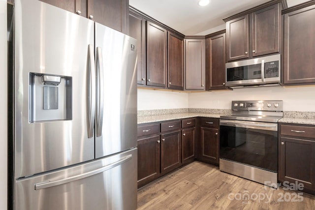 kitchen featuring light wood-style flooring, dark brown cabinets, and stainless steel appliances