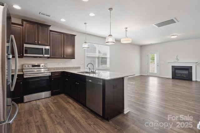kitchen with a sink, appliances with stainless steel finishes, dark brown cabinets, and visible vents