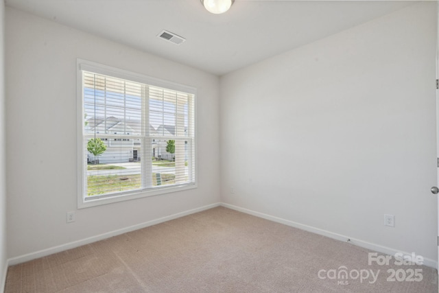 carpeted empty room with baseboards and visible vents