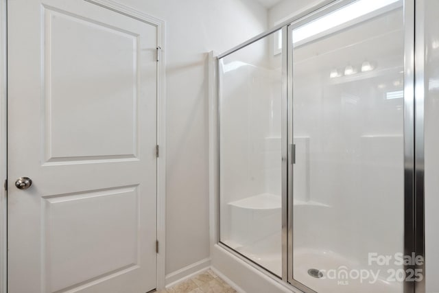 full bathroom with baseboards and a stall shower
