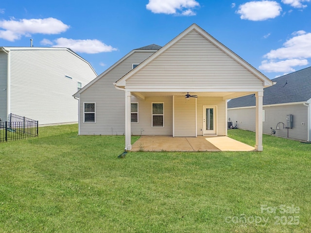 rear view of house featuring fence, a ceiling fan, a yard, and a patio area