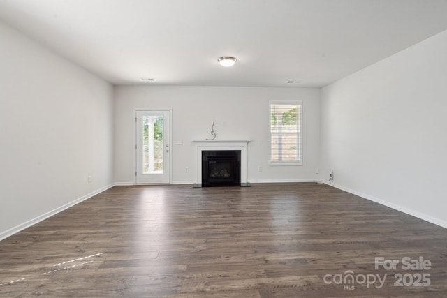4527 Dover Ct, Denver, NC 28037 - unfurnished living room with baseboards, a fireplace with flush hearth, dark wood finished floors, and a wealth of natural light