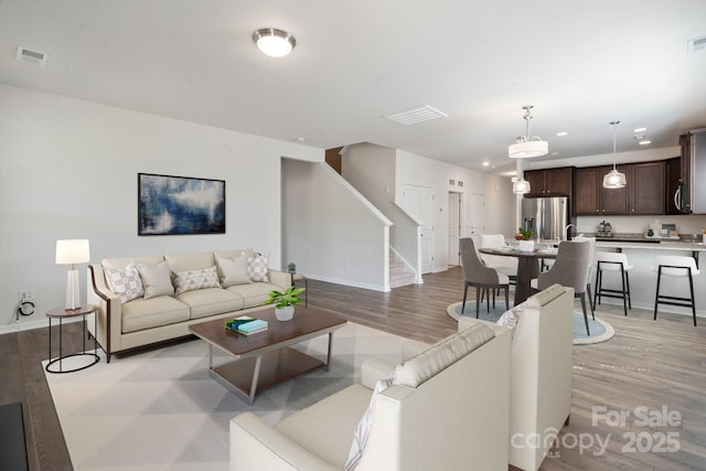 4527 Dover Ct, Denver, NC 28037 - living area featuring baseboards, visible vents, light wood-style flooring, and stairway