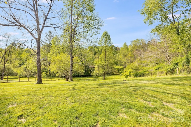 view of yard with fence and a wooded view