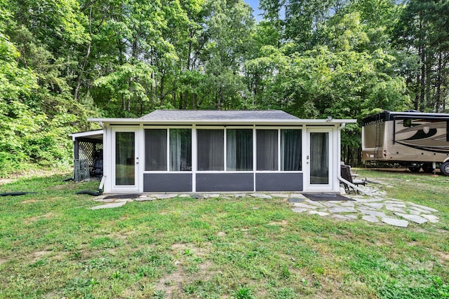 rear view of property with a sunroom and a lawn