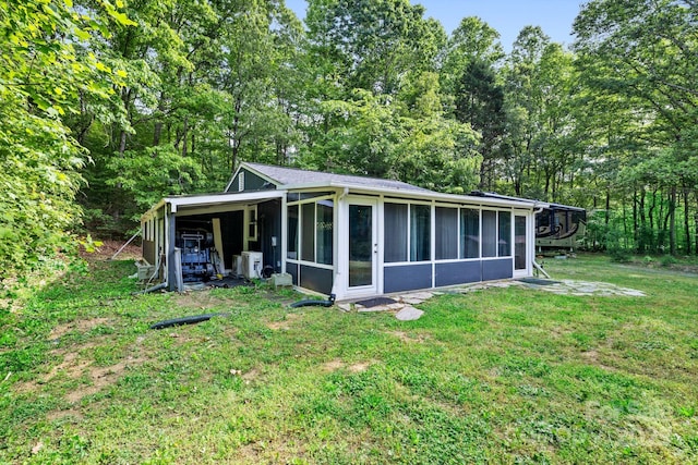 back of house with a sunroom, a lawn, and ac unit