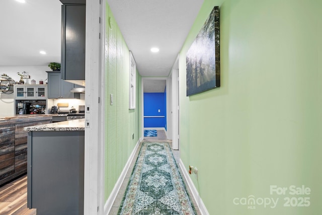 corridor featuring baseboards and recessed lighting