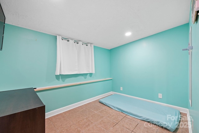 tiled empty room with baseboards and recessed lighting