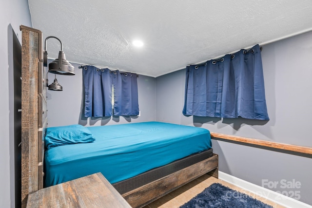 bedroom featuring a textured ceiling and baseboards