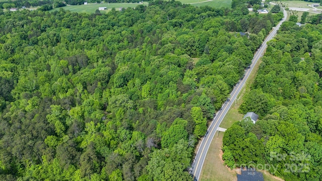 aerial view of property and surrounding area with a forest