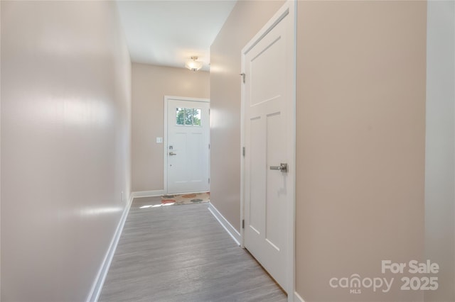 entryway featuring baseboards and wood finished floors
