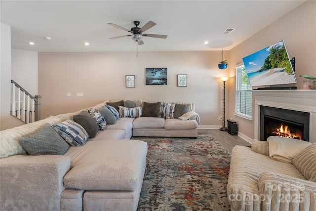 living room featuring a ceiling fan, visible vents, wood finished floors, baseboards, and recessed lighting