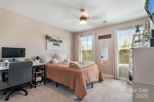bedroom featuring visible vents, baseboards, ceiling fan, and light carpet