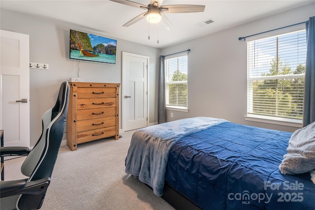 bedroom featuring baseboards, ceiling fan, light carpet, and visible vents