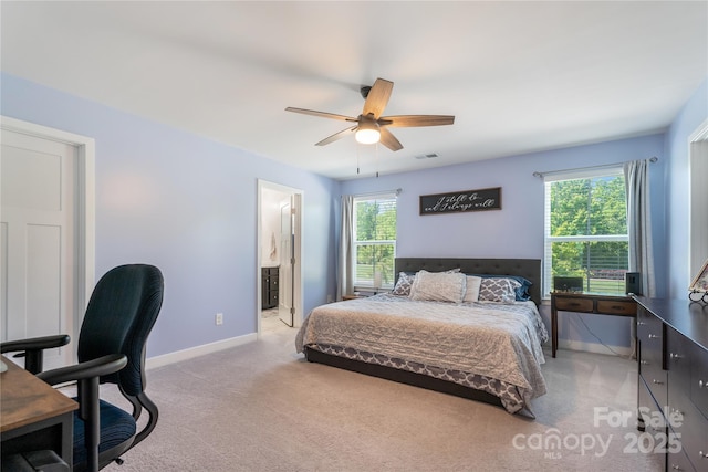 bedroom with a ceiling fan, visible vents, light colored carpet, baseboards, and connected bathroom