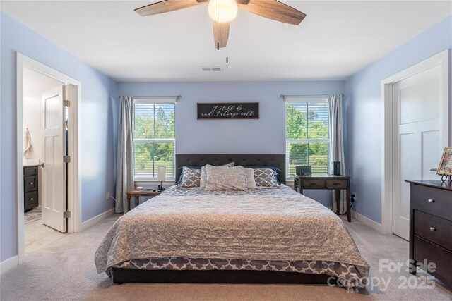 bedroom with light colored carpet, visible vents, and multiple windows