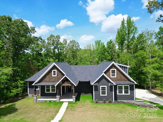 2694 Woodcrest Dr SW, Concord, NC 28027 - craftsman-style home with a porch, a shingled roof, stone siding, and a front yard