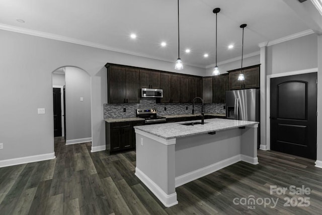 2694 Woodcrest Dr SW, Concord, NC 28027 - kitchen featuring a sink, appliances with stainless steel finishes, backsplash, and arched walkways