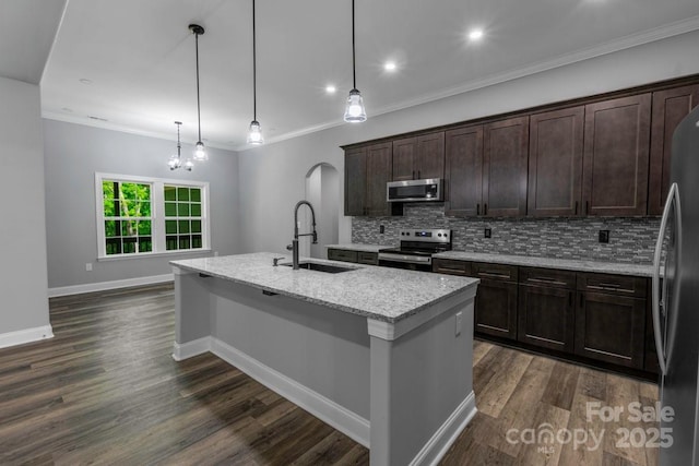 2694 Woodcrest Dr SW, Concord, NC 28027 - kitchen featuring a kitchen island with sink, dark wood-style flooring, appliances with stainless steel finishes, tasteful backsplash, and a sink