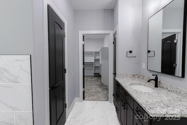 2694 Woodcrest Dr SW, Concord, NC 28027 - bathroom with vanity, baseboards, a spacious closet, and marble finish floor