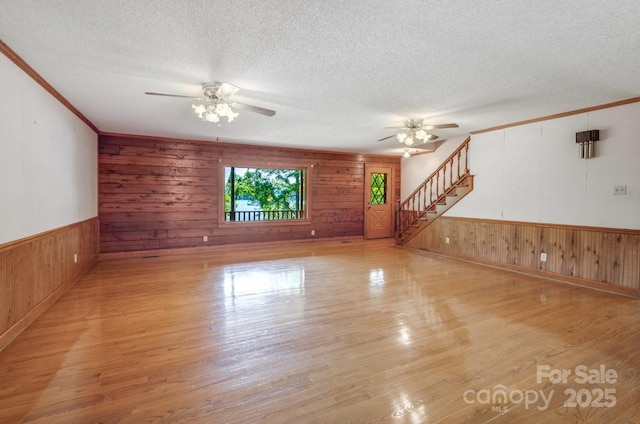 993 Jackson Rd, Fort Lawn, SC 29714 - unfurnished living room featuring wood finished floors, a textured ceiling, crown molding, ceiling fan, and wooden walls
