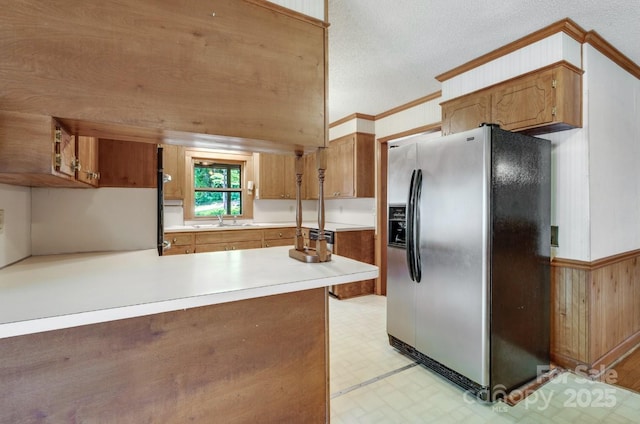 993 Jackson Rd, Fort Lawn, SC 29714 - kitchen with a sink, wood walls, ornamental molding, stainless steel refrigerator with ice dispenser, and light countertops