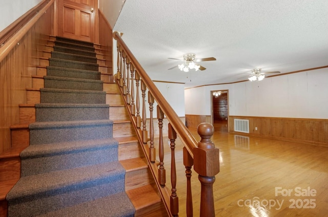 993 Jackson Rd, Fort Lawn, SC 29714 - staircase featuring a wainscoted wall, a textured ceiling, wood finished floors, and ceiling fan