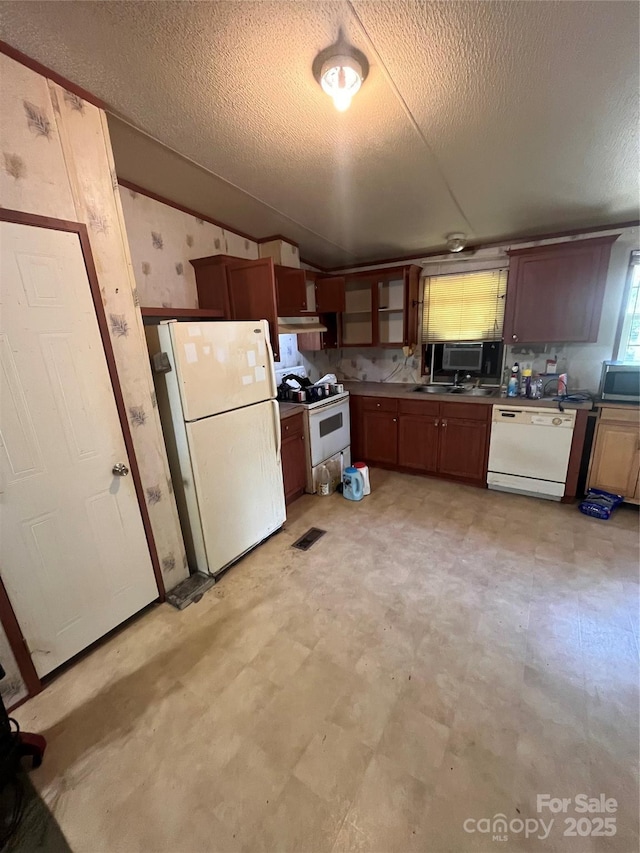 515 Willow St, Lincolnton, NC 28092 - kitchen with white appliances, a textured ceiling, vaulted ceiling, light floors, and visible vents